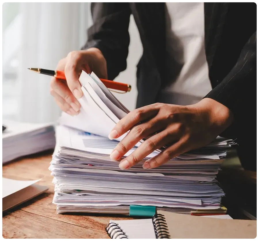 Business professional reviewing paperwork pile