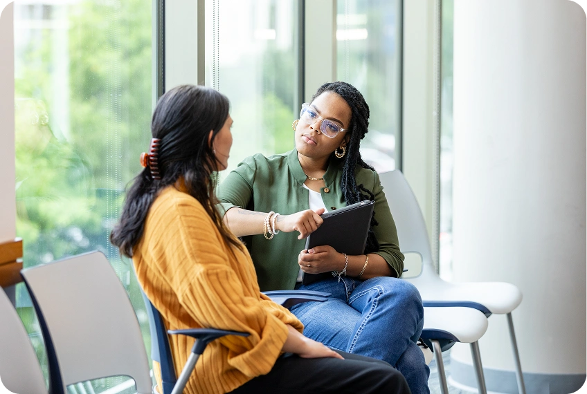 Women discussing near large windows